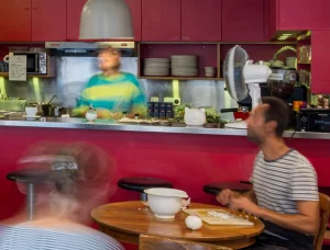 Des personnes assises autour d'une table cuisinant